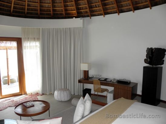 Seating area and bedroom of an over the water villas at W Hotel and Resort in the Maldives.