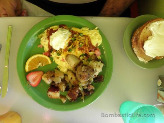 The Mexican – Scrambled eggs with chilies, tomatoes, and cheddar topped with Mexican gravy, green onions, cheddar and sour cream, taters and toast on the side.
