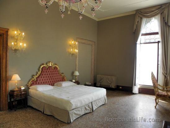 Bedroom area of a Canal View Deluxe Suite at Ca Sagredo Hotel in Venice.