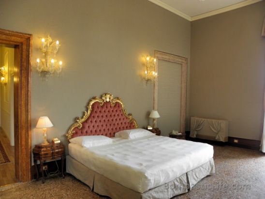 Bedroom area of a Canal View Deluxe Suite at Ca Sagredo Hotel in Venice.